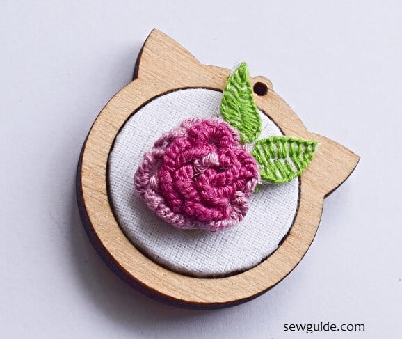 3-d embroidery rose flower with cast on stitch on a wood pendant