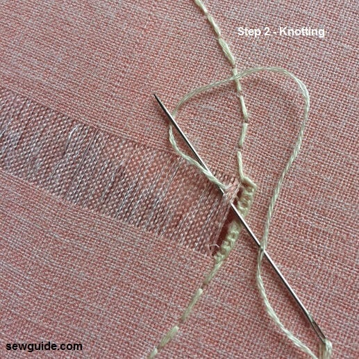 start knotting the thread from the drawn threads on the fabric 