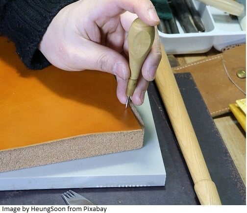 making holes in leather with awl for hand sewing leather